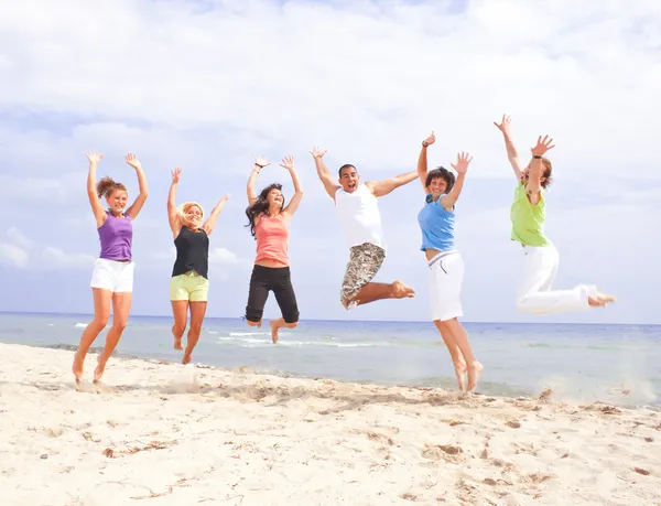 Gelukkig springen op het strand — Stockfoto