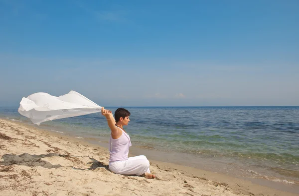 Femme heureuse avec un foulard sur la plage — Photo