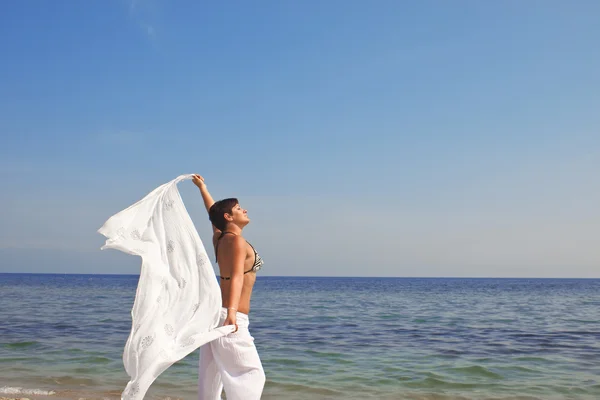 Glückliche Frau mit Schal am Strand — Stockfoto
