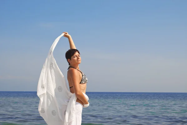 Junge Frau mit Schal am Strand — Stockfoto