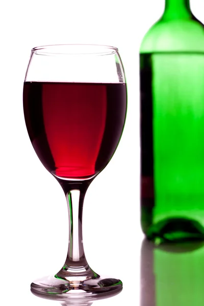 Glas rött vin och grön flaska — Stockfoto