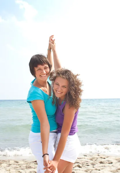 Счастливые девушки веселятся на пляже — стоковое фото