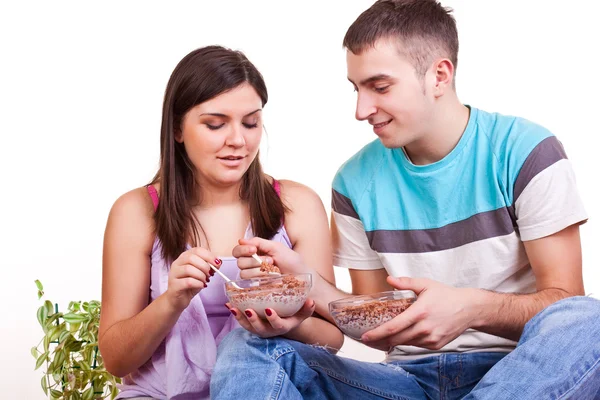 Couple assis sur le sol et mangeant — Photo