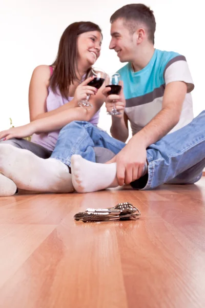 Keys and young couple on the floor — Stock Photo, Image