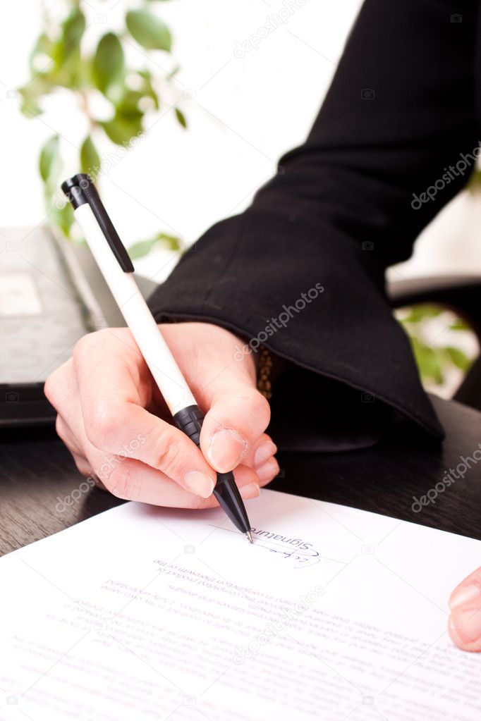 Close-up of signing document