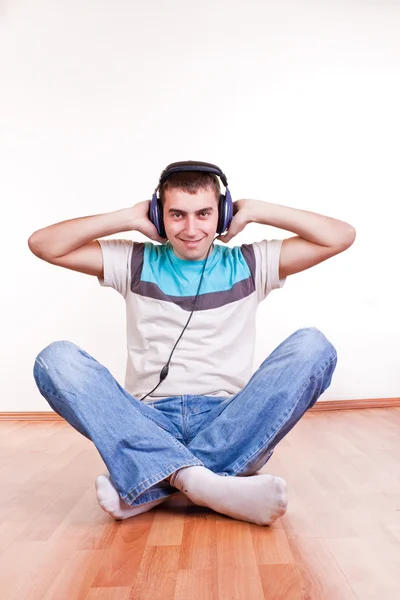 이어폰으로 바닥에 젊은 남자 — 스톡 사진