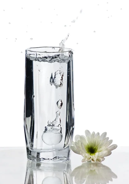 Su ve çiçekli bir bardak su. — Stok fotoğraf