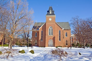 Old chapel on a college campus in winter clipart