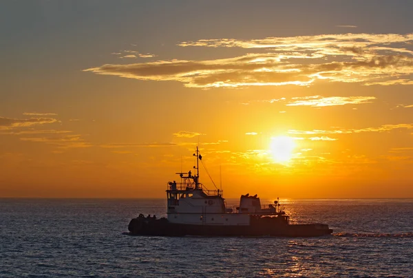 Silhouette eines Schlepperbootes bei Sonnenuntergang — Stockfoto