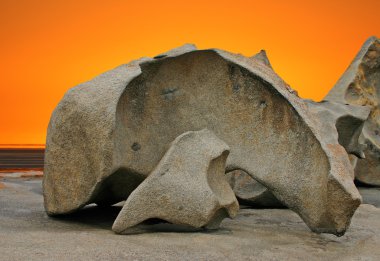 Sculpted rock formation and orange sky clipart