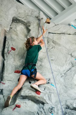 Young teen girl rock climbing clipart