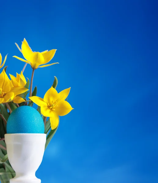 Ovo de Páscoa azul e tulipas amarelas — Fotografia de Stock