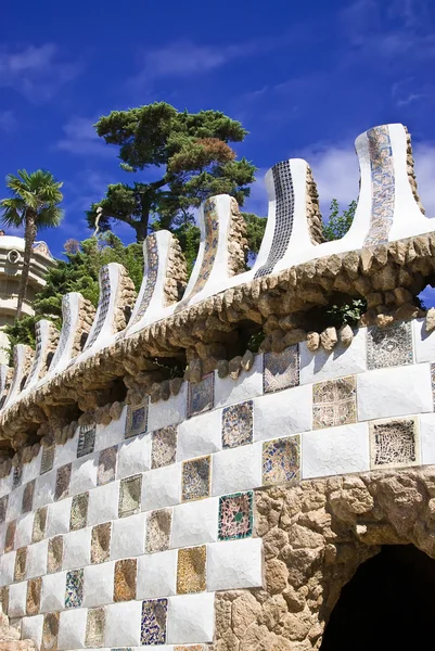 Una barandilla de piedra con azulejos y un montón de detalles con estilo de antonio gaudí en el guell del parque — Foto de Stock