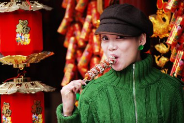 China girl eating candied fruit clipart