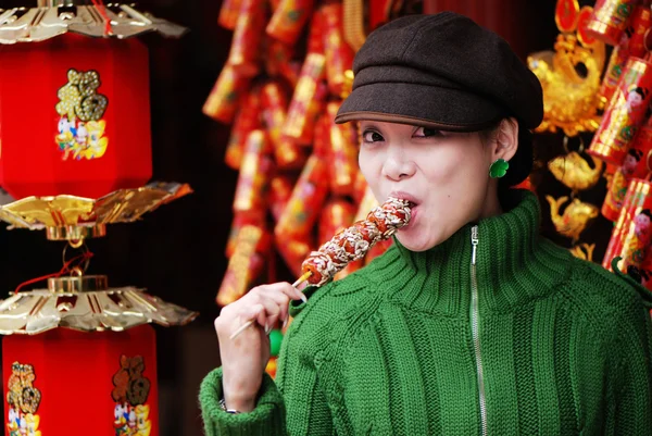 Kínai lány eszik kandírozott gyümölcs — Stock Fotó