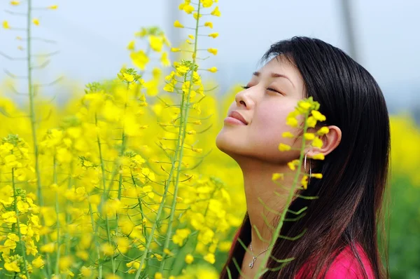 Pretty girl in rape flowers — Stock Photo, Image