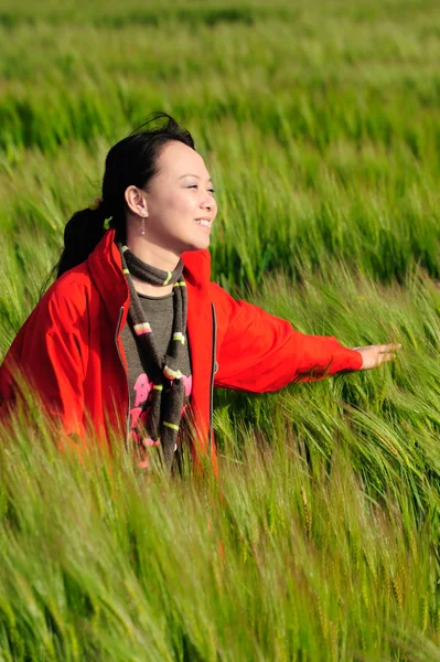 Trawa Azji kobieta w czerwonym — Zdjęcie stockowe