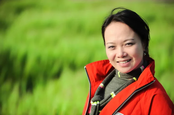 Aziatische vrouw gras in het rood — Stockfoto