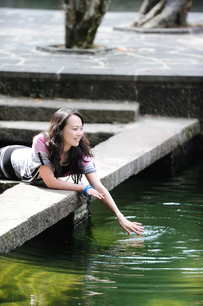 Chinese girl playing by water — Stock Photo, Image