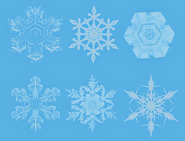 Lite niebieski płatki śniegu na niebieskim tle — Zdjęcie stockowe