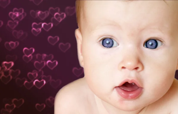 Bebé niña con corazones en el fondo —  Fotos de Stock