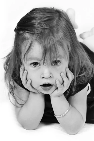 Klein meisje in een rode jurk met handen op gezicht — Stockfoto