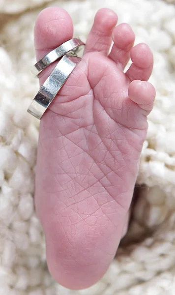 Bebés pie tomado primer plano con anillos — Foto de Stock