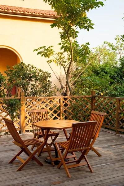 Σπίτι patio διαθέτει ξύλινο τραπέζι και καρέκλες — Φωτογραφία Αρχείου