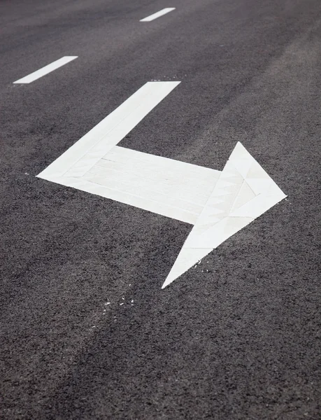 Carretera señaliza flechas en superficie asfaltada — Foto de Stock