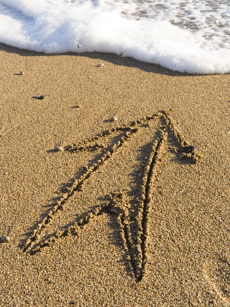 Стрела на мокром морском песке — стоковое фото
