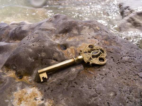 Schlüssel auf einem nassen Stein — Stockfoto