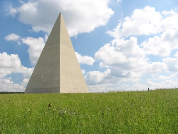 Pirâmide vale a pena em um campo verde — Fotografia de Stock