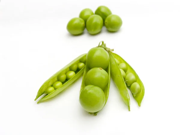 Green peas and fruits plums in a pod — Stock Photo, Image