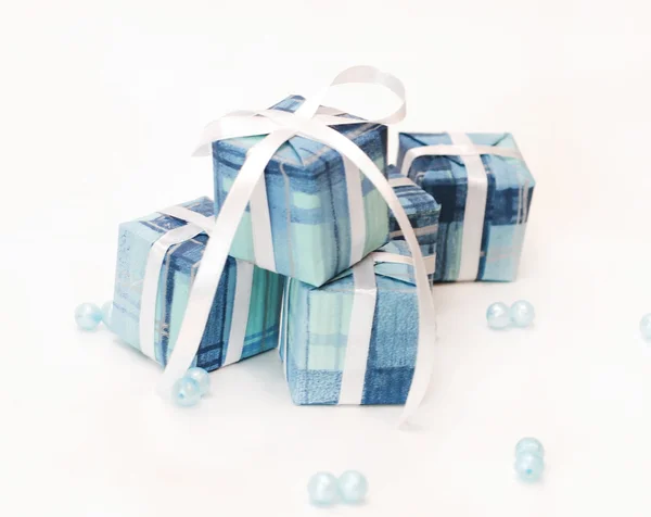 Regali in imballaggio blu con un nastro bianco — Foto Stock