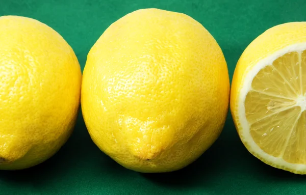 Tre citroner på en grön bakgrund — Stockfoto