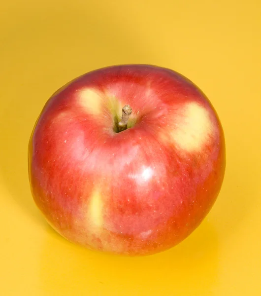 Red apple on a yellow background — Stock Photo, Image