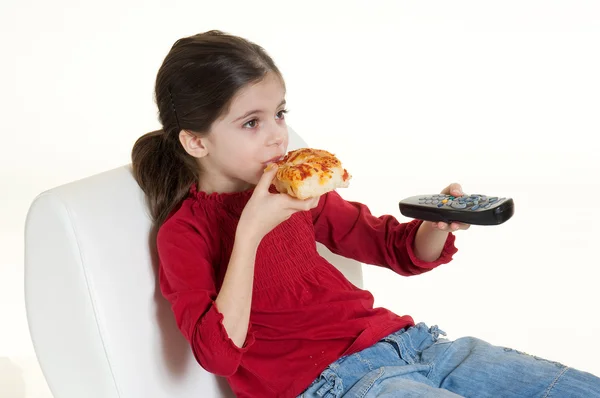 Dziecko jedzenie pizzy z pilotem zdalnego sterowania — Zdjęcie stockowe