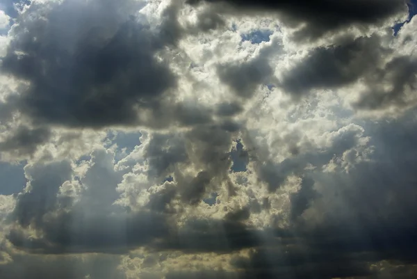 Sun appearance through dark clouds — Stock Photo, Image