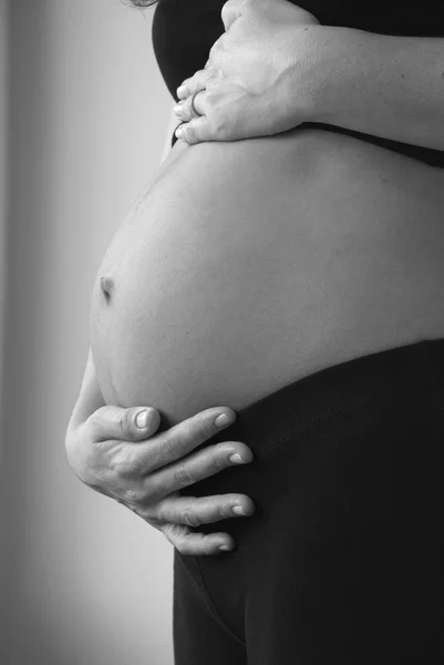 35 тижнів вагітна жінка тримає живіт Стокове Зображення