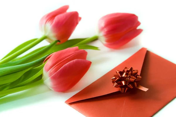 Красный конверт и красные тюльпаны — стоковое фото