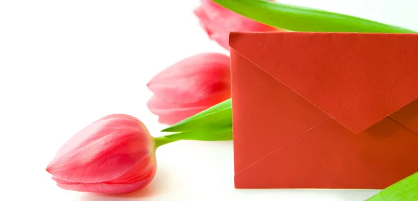 Roter Umschlag und ein Strauß Tulpen Stockbild