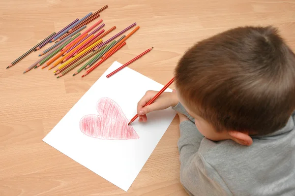 Ребенок рисует сердце на бумаге — стоковое фото