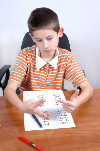 Мальчик делает тест по математике — стоковое фото