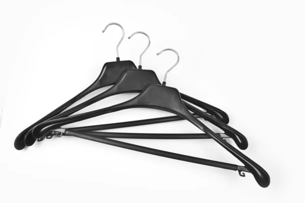 Three black plastic coat hangers — Stock Photo, Image
