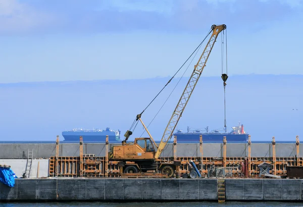 Crane, quay and ships in background — Stock Photo, Image