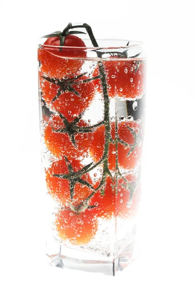 Tomates dans l'eau minérale Photo De Stock