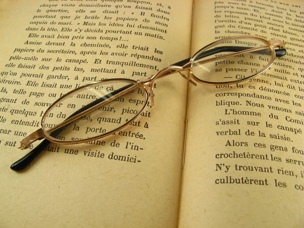 Óculos em um livro — Fotografia de Stock