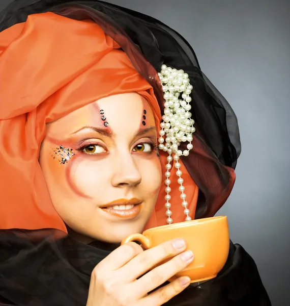 Молода жінка в чорному і помаранчевому тюрбані — стокове фото