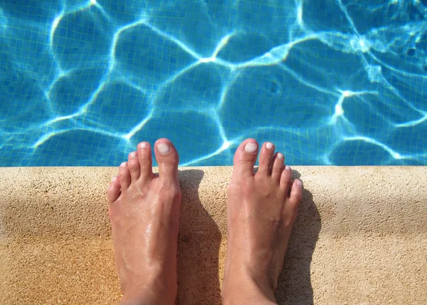 Woman's feet in the pool — Stock Photo, Image