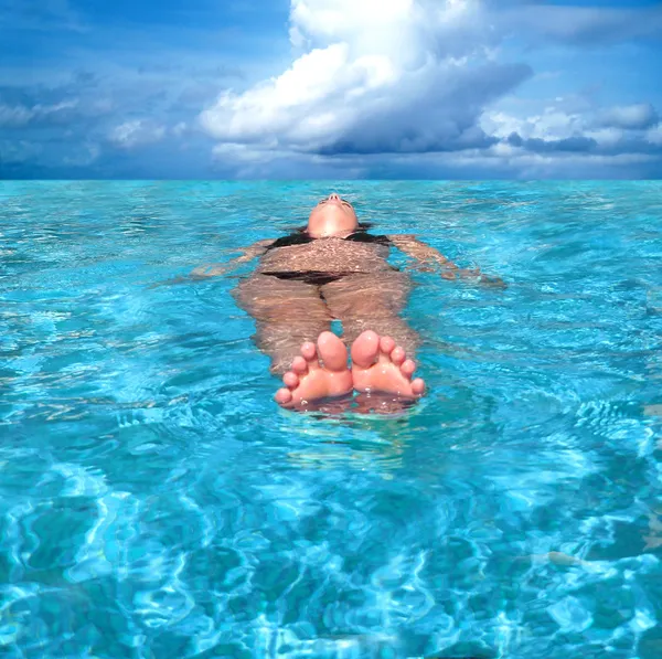 Femme flottant dans la mer — Photo